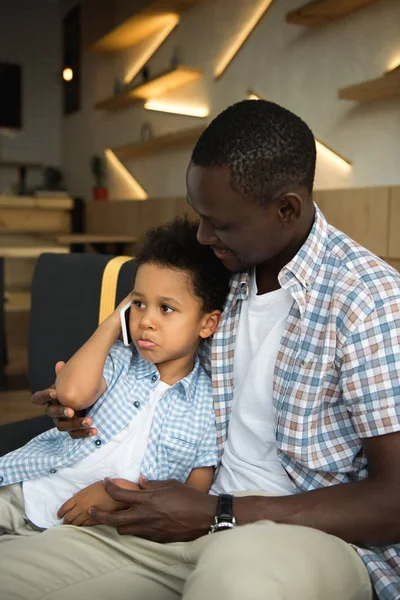 African american father and son with smartphone — Stock Photo