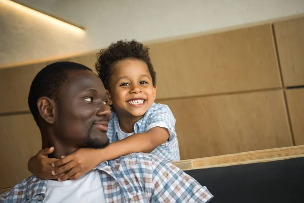 Africano americano padre y niño abrazos - foto de stock