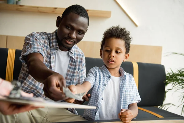 Père et fils payant la facture — Photo de stock