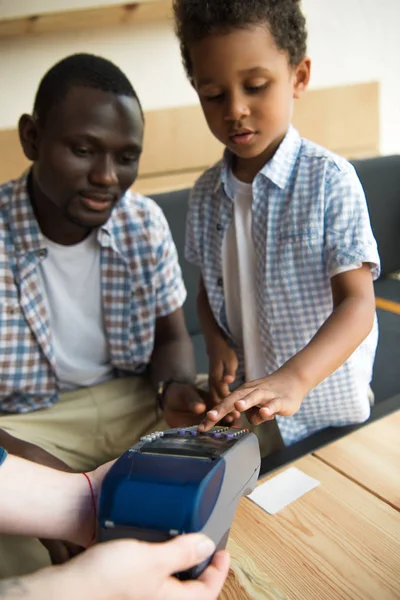 Father and son paying bill — Stock Photo