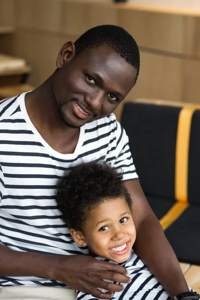 Africano americano padre y niño abrazos - foto de stock