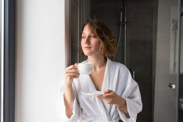 Mädchen im Bademantel trinkt Kaffee — Stockfoto