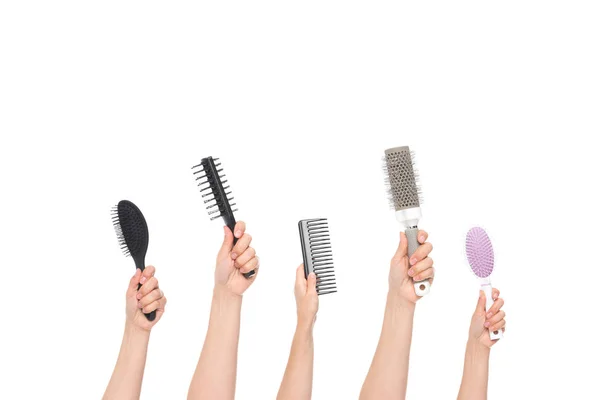 Mani che tengono spazzole per capelli — Foto stock