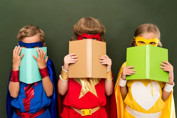 Pequeños superhéroes con libros - foto de stock