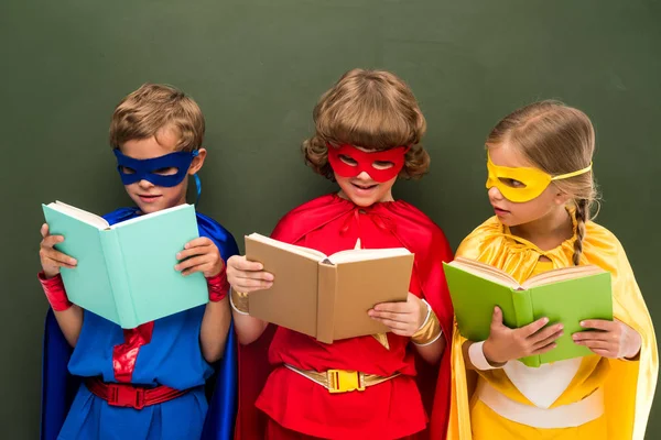 Superheroes reading books — Stock Photo