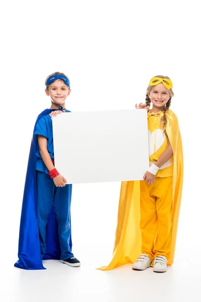 Superhéroes sosteniendo tablero en blanco - foto de stock