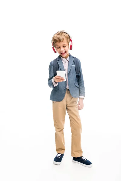 Schoolboy using headphones and smartphone — Stock Photo
