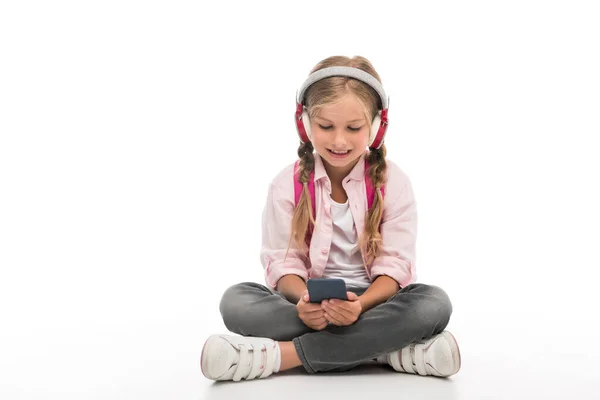 Colegiala con smartphone y auriculares - foto de stock