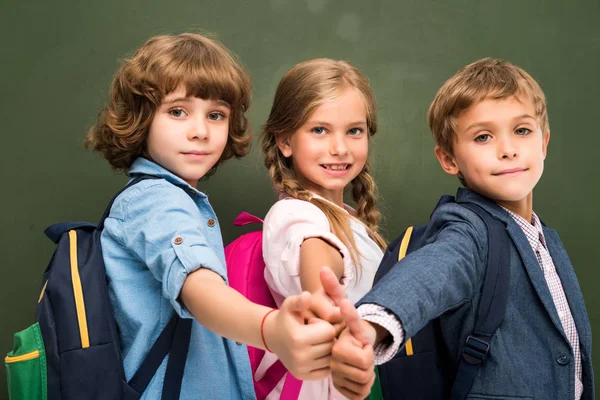 Schoolchildren showing thumbs up — Stock Photo