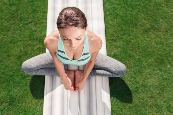 Mujer relajada sentada en postura de yoga - foto de stock