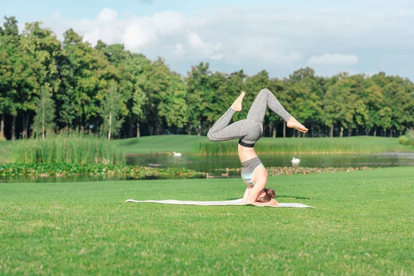 Donna che esegue posa poggiatesta yoga — Foto stock