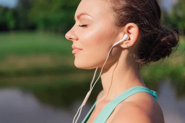 Woman listening music in earphones — Stock Photo