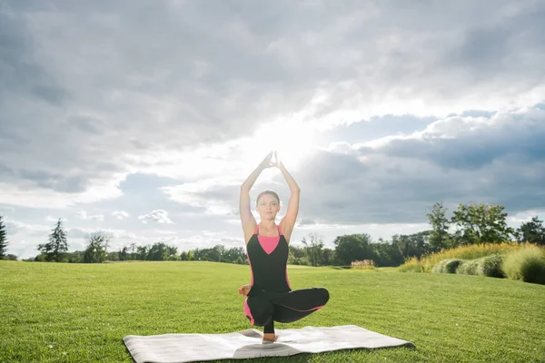 Mujer realizando pose de toestand yoga - foto de stock
