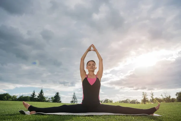 Жінка сидить у позі йоги в парку — стокове фото