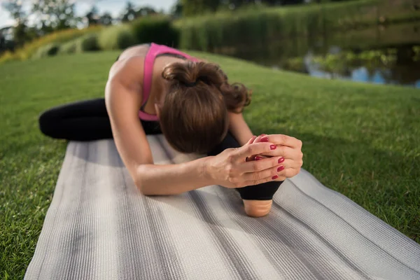 Mujer practicando yoga en la estera - foto de stock