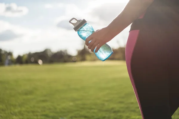 Femme tenant bouteille d'eau — Photo de stock