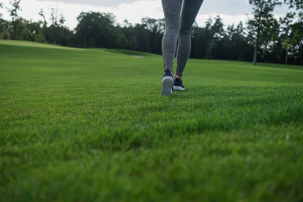Женщина бежит по зеленой лужайке — стоковое фото