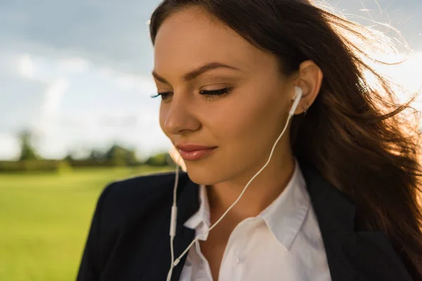 Businesswoman in earphones — Stock Photo