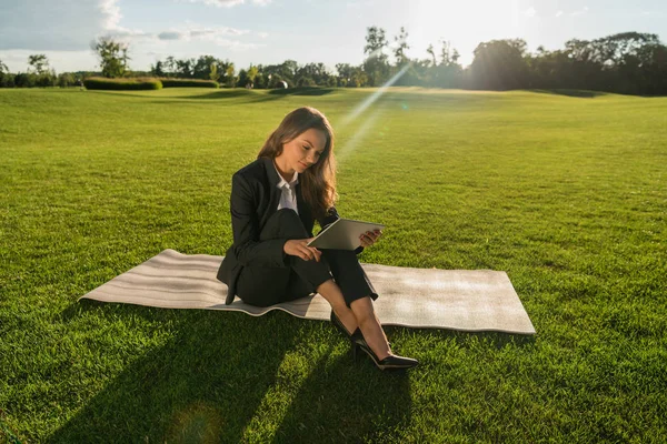 Femme d'affaires avec tablette sur pelouse verte — Photo de stock