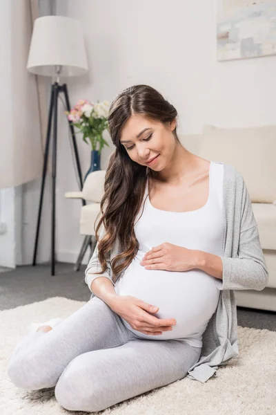Pregnant woman touching belly — Stock Photo