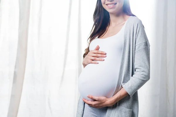 Pregnant woman touching belly — Stock Photo