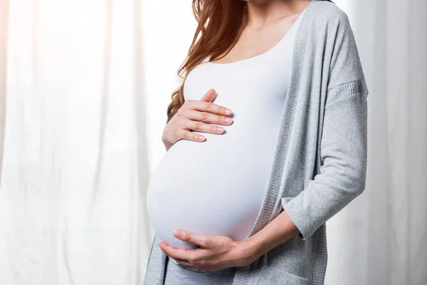 Pregnant woman touching belly — Stock Photo