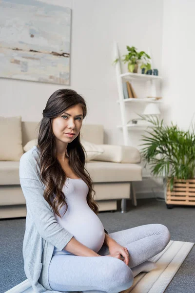 Pregnant woman sitting in lotus pose — Stock Photo