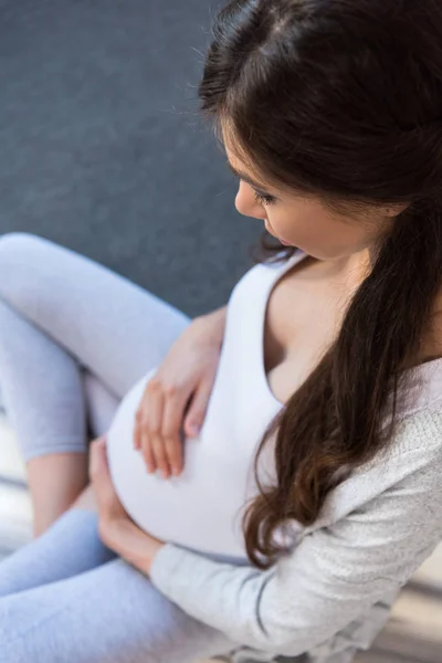 Pregnant woman touching belly — Stock Photo