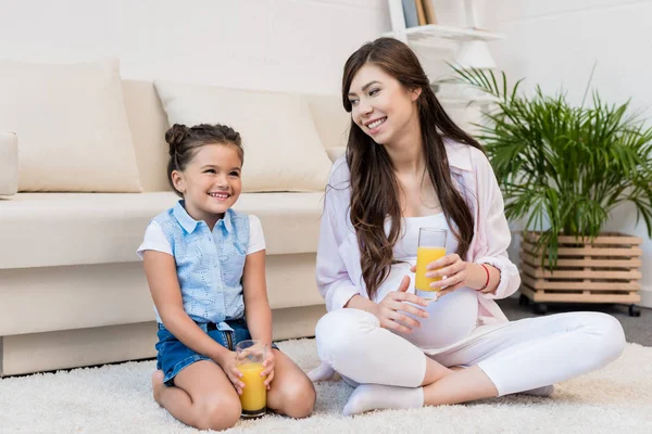 Femme enceinte et fille avec des verres de jus — Photo de stock