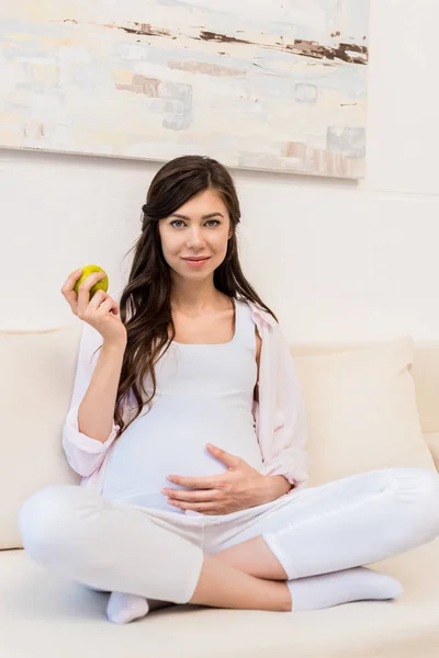 Беременная женщина держит яблоко — стоковое фото