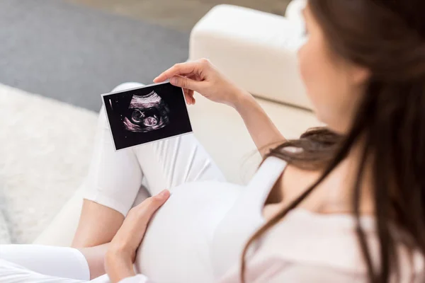 Femme enceinte regardant une image échographique — Photo de stock