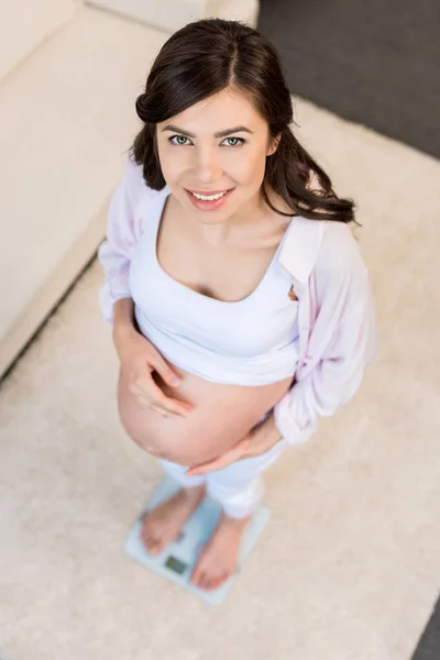 Mulher grávida em pé em escalas — Fotografia de Stock