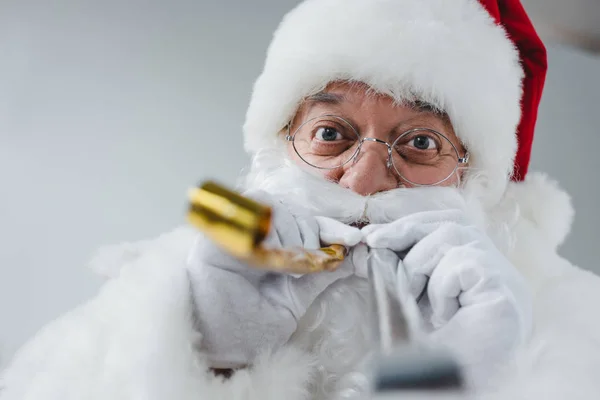 Santa claus with party blowers — Stock Photo