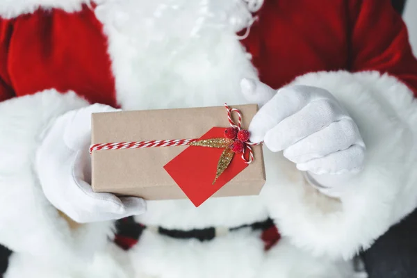 Santa claus with wrapped gift — Stock Photo