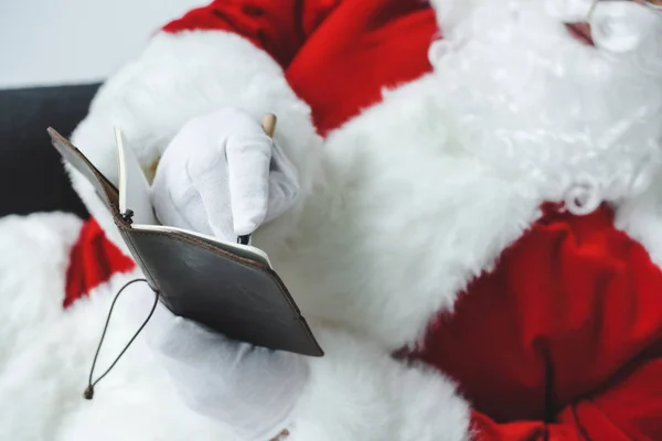 Santa claus writing in notebook — Stock Photo