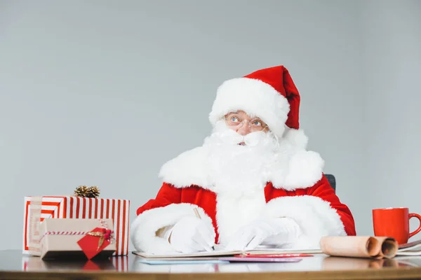 Weihnachtsmann schreibt am Tisch — Stockfoto