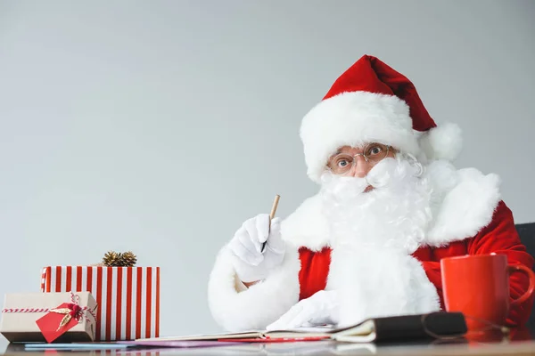 Santa claus writing at table — Stock Photo