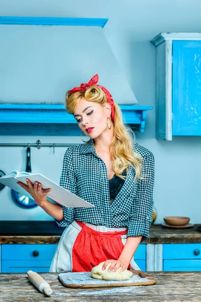 Housewife reading cookbook — Stock Photo