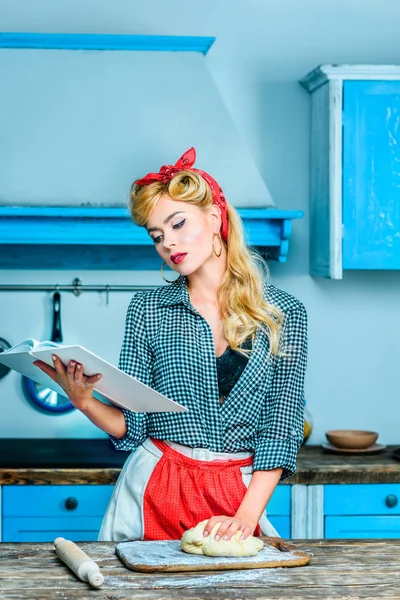 Femme au foyer lecture livre de cuisine — Photo de stock