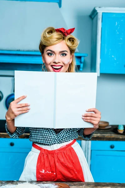 Femme au foyer montrant livre de cuisine — Photo de stock
