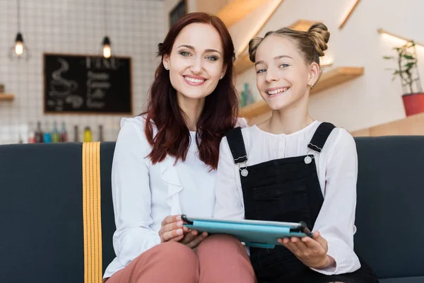 Mother and daughter with tablet in cafe — Stock Photo