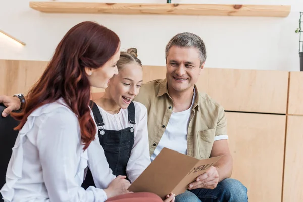 Famille regardant la liste des menus dans le café — Photo de stock