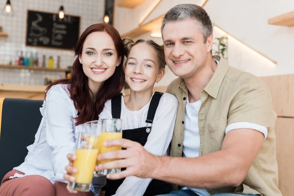 Family clinking with glasses of juice — Stock Photo