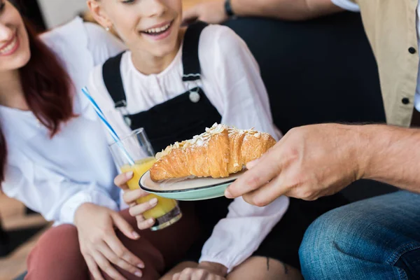 Hombre dando croissant a hija y esposa - foto de stock