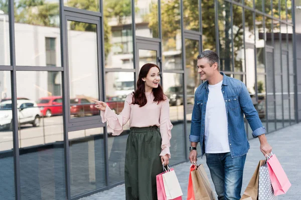 Mature couple with shopping bags — Stock Photo