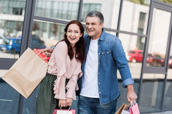 Mature couple with shopping bags — Stock Photo