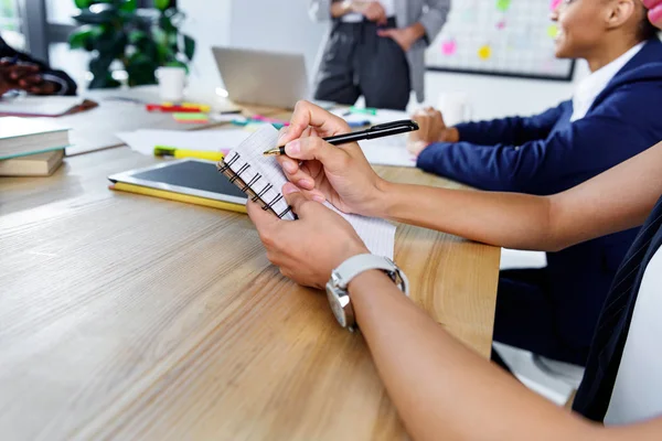 Geschäftsfrau schreibt in Notizbuch — Stockfoto