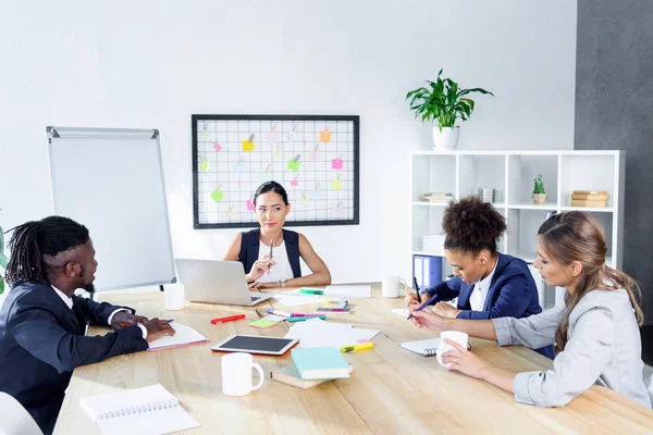 Compañeros de negocios multiétnicos en la reunión - foto de stock