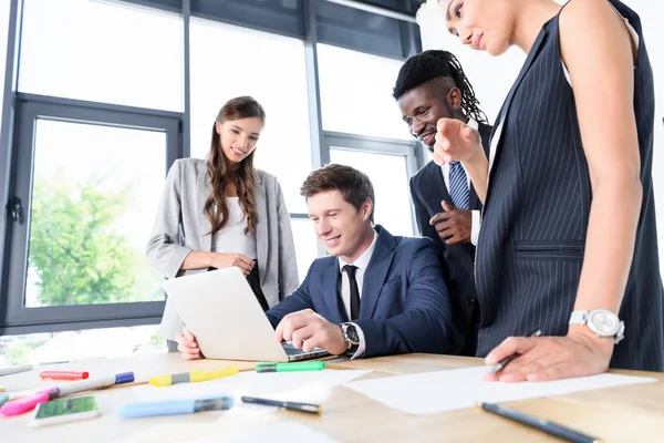 Multiethnic business people with laptop — Stock Photo