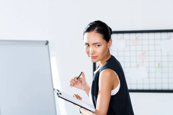 Mujer de negocios asiática con portapapeles - foto de stock